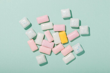 Various types of mint and fruit gum on mint color background top view