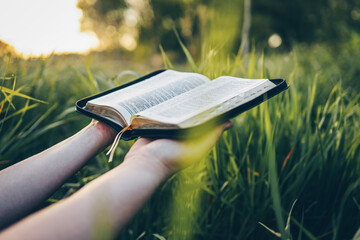 Open bible in hands close-up, concept of calmness and morning solitude
