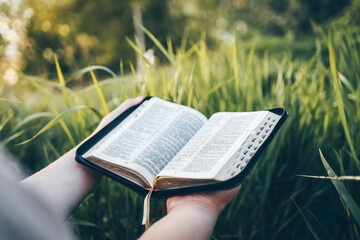 Open bible in hands close-up, concept of calmness and morning solitude