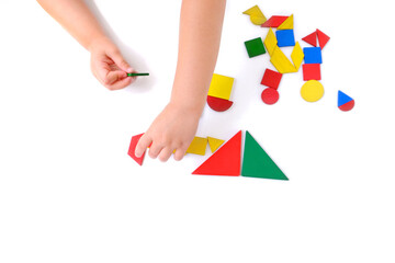 children's hands create pictures from colored wooden geometric shapes, little child, girl 3 years...