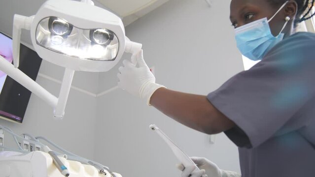 Young female dentist Preparing materials before surgery wearing a mask and looking at camera