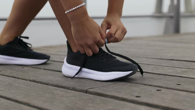 Close up of woman tying shoe laces before running outdoors.