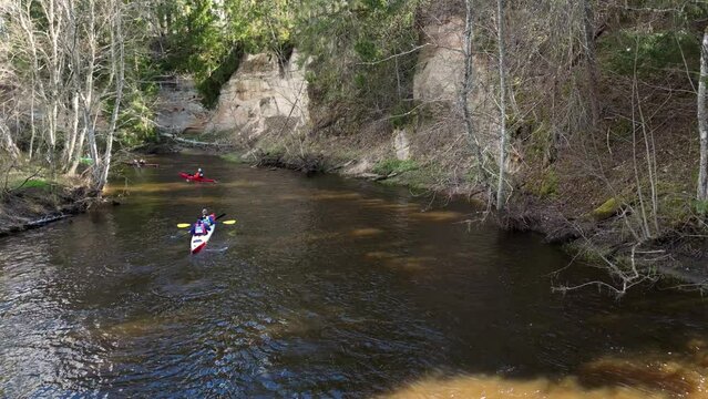 Drone shot on a sports canoe driven by a team of men and women sailing along a river. Outdoor activities on a kayak, water sports. Go Everywhere. Family Sports. Summer. Sport canoe operated by team