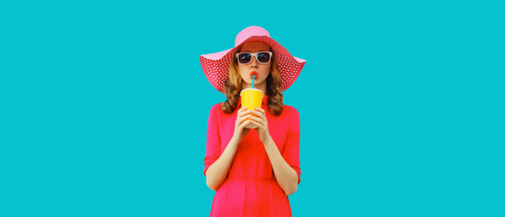 Summer portrait of beautiful young woman drinking fresh juice wearing straw round hat, pink dress...