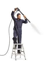 Man in a uniform using a pressure washer and standing on a ladder