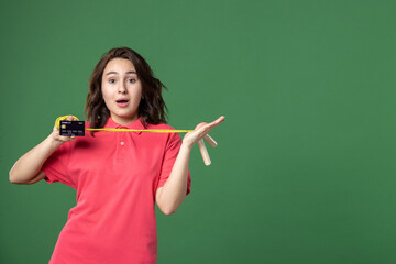 front view young saleswoman holding bank card and skipping rope on green background sport boutique job shopping money present sale