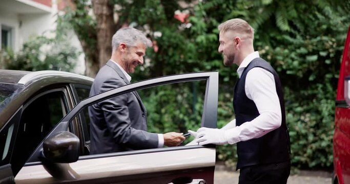 Man Giving Car Key To Male Valet