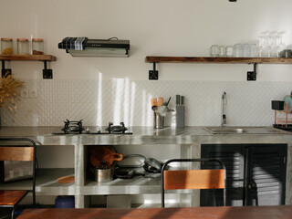 Modern kitchen interior with dining table with retro decor elements, vintage fixtures, stylish interior, concrete and wood elements.