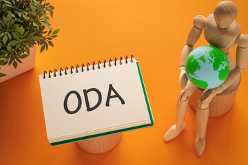 There is notebook with the word ODA. It is an abbreviation for Official Development Assistance as...
