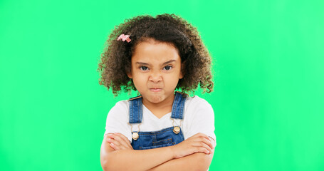 Child, angry and face with arms crossed on green screen with attitude, problem or frustrated in...