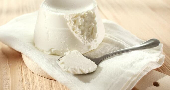 ricotta cheese. traditional italian cheese on a white napkin. ingredients for tortellini or tortelloni pasta. visual recipe. sunny day. angle view. smooth zoom camera movement. macroshot.
