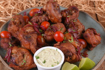 fried chicken with tomatoes and caramelized onions wings with herb sauce