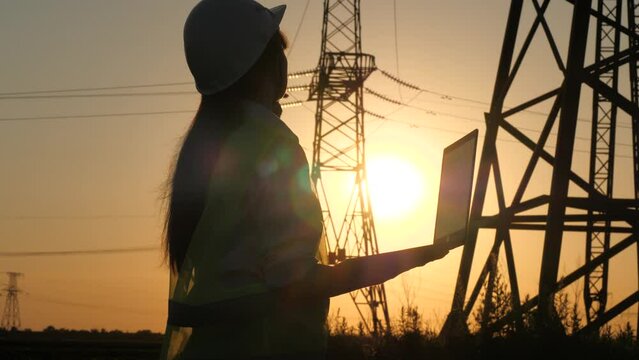 silhouette electrical engineer, work laptop sunset, electric tower, digital hand, silhouette engineer helmet, builder discussing project, reading tablet, people working electrical room, concept