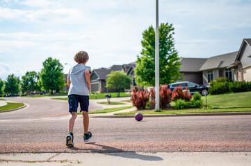 Chasing a ball that has crossed the street by rolling into a road.