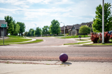Chasing a ball that has crossed the street by rolling into a road.