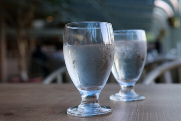 two glasses of water on table misted glass cold drink pure water diet health dripping droplets flow down glass wooden table blurred background on empty stomach drinking clean water spring water