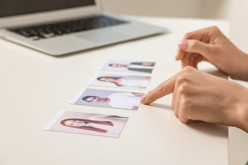 Human resources manager choosing employee among different applicants at table, closeup