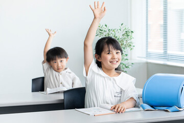 授業で手を挙げる子ども　child raising hand in class	