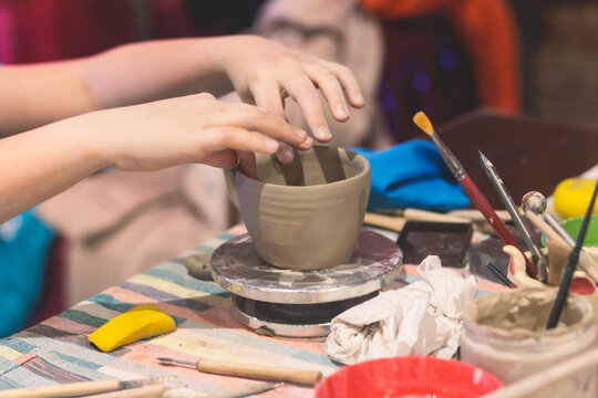 Pottery lesson master class for kids children, process of making clay pot on pottery wheel, potter wet hands creating ceramic crockery handcrafts, ceramist molding jar or vase