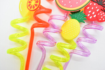 close up colorful fruit drinking staws on white background