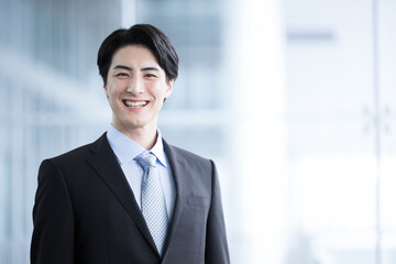 Smile for the camera of a male businessman who looks like a handsome mid-level employee.