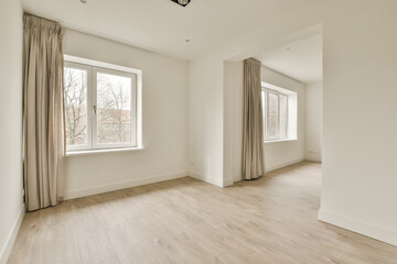 an empty room with white walls and wood flooring, there is a large window in the wall to the right