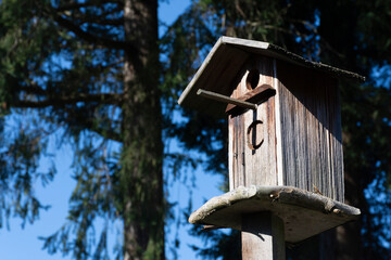 An image of an old retro styled bird house with sun bleached and faded wood.