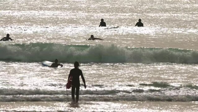 People surfing in the ocean at early evening