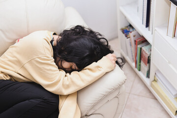 Depressed young woman lying on couch at home, frustrated, sleeping, drowsing, feeling stress, apathy, suffering from mental breakdown. Psychological and mental troubles