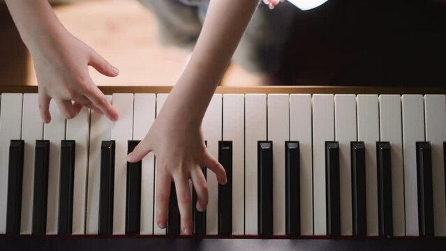 Student of music school studies types of musical articulation. Girl practices performing composition with staccato upper view on blurred background