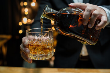 Barman pouring whiskey whiskey glass..