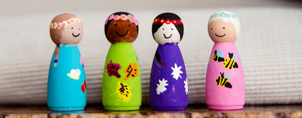 Painted wooden peg dolls of different races; small wooden dolls painted by a child
