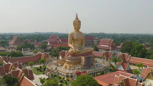 Aerial top view of The Giant Golden Buddha in Wat Muang in Sing Buri district near Bangkok. Urban town city, Thailand.