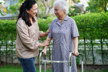 Caregiver help Asian elderly woman disability patient sitting on wheelchair in park, medical...