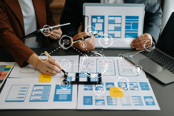 Close up view of UI developer team brainstorming on their project with laptop, smartphone and...