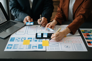  UX developer and ui designer brainstorming about mobile app interface wireframe design with...