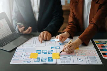  UX developer and ui designer brainstorming about mobile app interface wireframe design with...