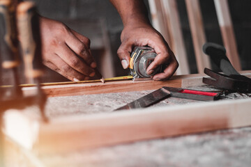 Carpenter working with equipment on wooden table, And measurement of a wooden plank
