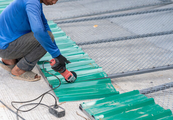 Worker use grinder cutting galvanized metal sheet.
