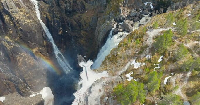 Drone reveal rainbow in V&oslash;ringsfossen waterfall mist in steep Norway canyon