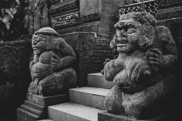 A couple of welcoming stone statue in front of a temple in Bali