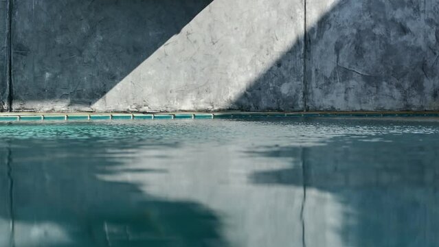 water wave of blue swimming pool on cement wall, construction industry