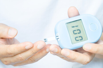 hand of people check diabetes and high blood glucose monitor with digital pressure gauge. Healthcare and Medical concept.