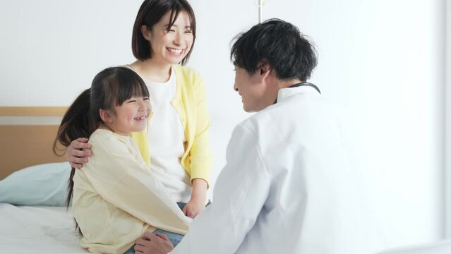 入院している女の子を診察する医師　小児科医