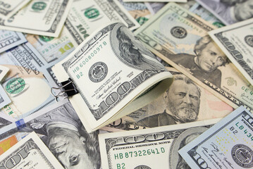 One hundred dollars close-up in large quantities lie on the table. Much money.