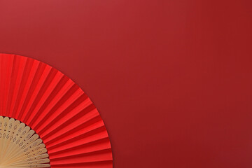 A red hand fan on a red background. Chinese, Japanese, Asian background.