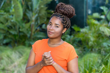 Smiling young adult woman from Africa with orange shirt