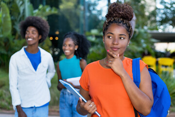 Thinking african american female student with group of black young adults