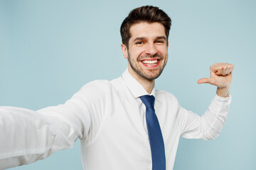 Close up young employee business man corporate lawyer wears classic formal shirt tie work in office do selfie shot pov on mobile cell phone point on himself isolated on plain blue background studio.