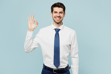 Young satisfied successful employee business man corporate lawyer wear classic formal shirt tie work in office showing okay ok gesture isolated on plain pastel light blue background studio portrait.